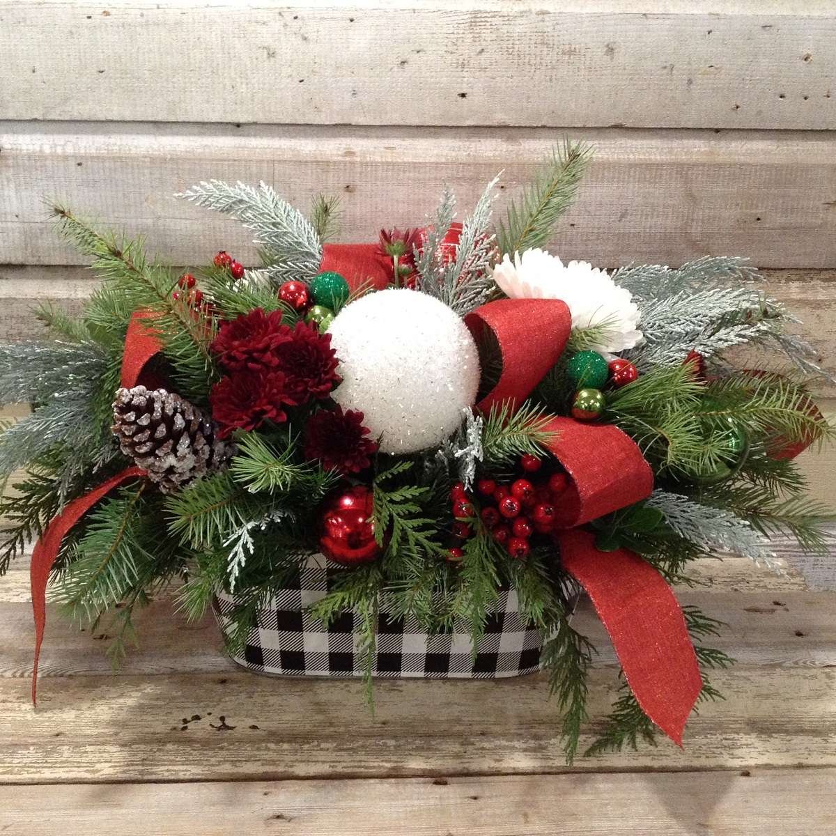 Christmas Floral arrangment with winter greens red and white flowers with a buffalo plaid tin container