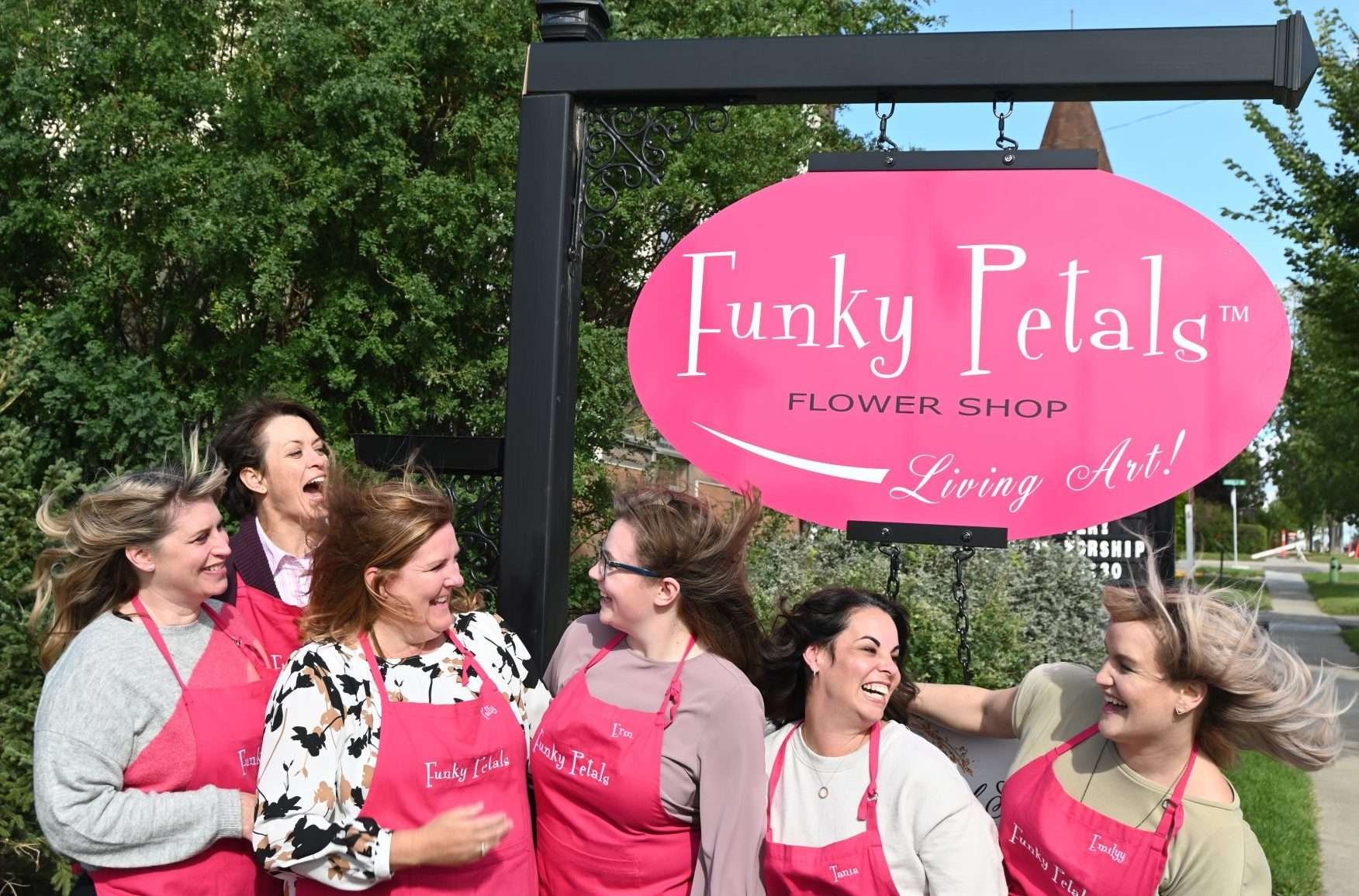 funky petals team in front of sign on windy day